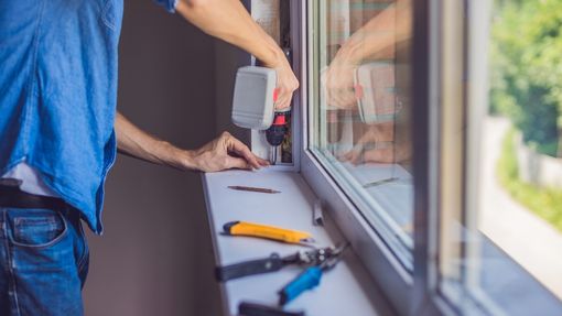 Worker performing window replacement on a home
