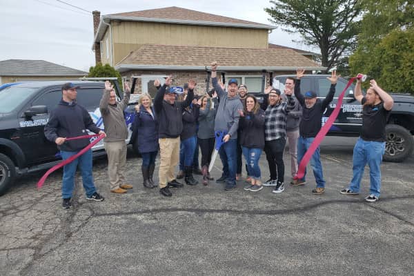 Roofing company team celebrating at Renowned Building Solutions in McHenry, IL