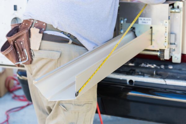 A seamless gutter is created by a machine and measured